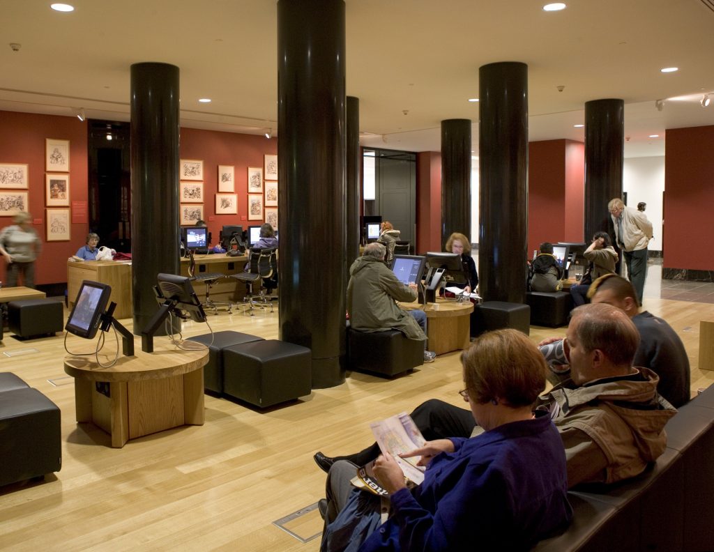 The National Gallery's Espresso Bar, showing a series of ArtStart collection information touch-screen kiosks with audio wands, placed on low tables with stools and a bench with swivel chairs.